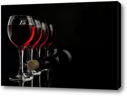    Силуэты нескольких бокалов с вином и бутылкой на черном фоне