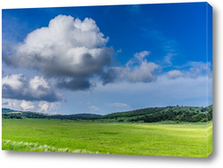   Постер Пейзаж с холмистым рельефом и зеленой травой.