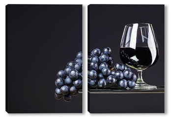 Модульная картина Бокал вина и виноград на темном фоне